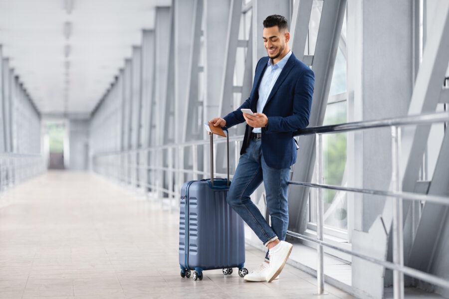 Business man relaxing with smartphone while waiting for flight in airport